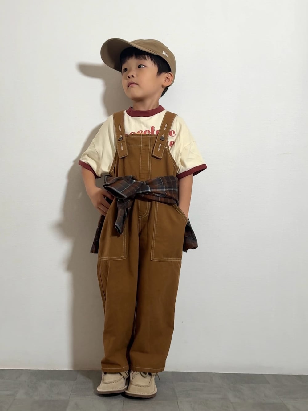 ブラウン系のTシャツ/カットソー、ベージュ系のモカシン/デッキシューズ、オレンジ系のシャツ/ブラウスを着用したキッズの秋コーディネートの2枚目の写真