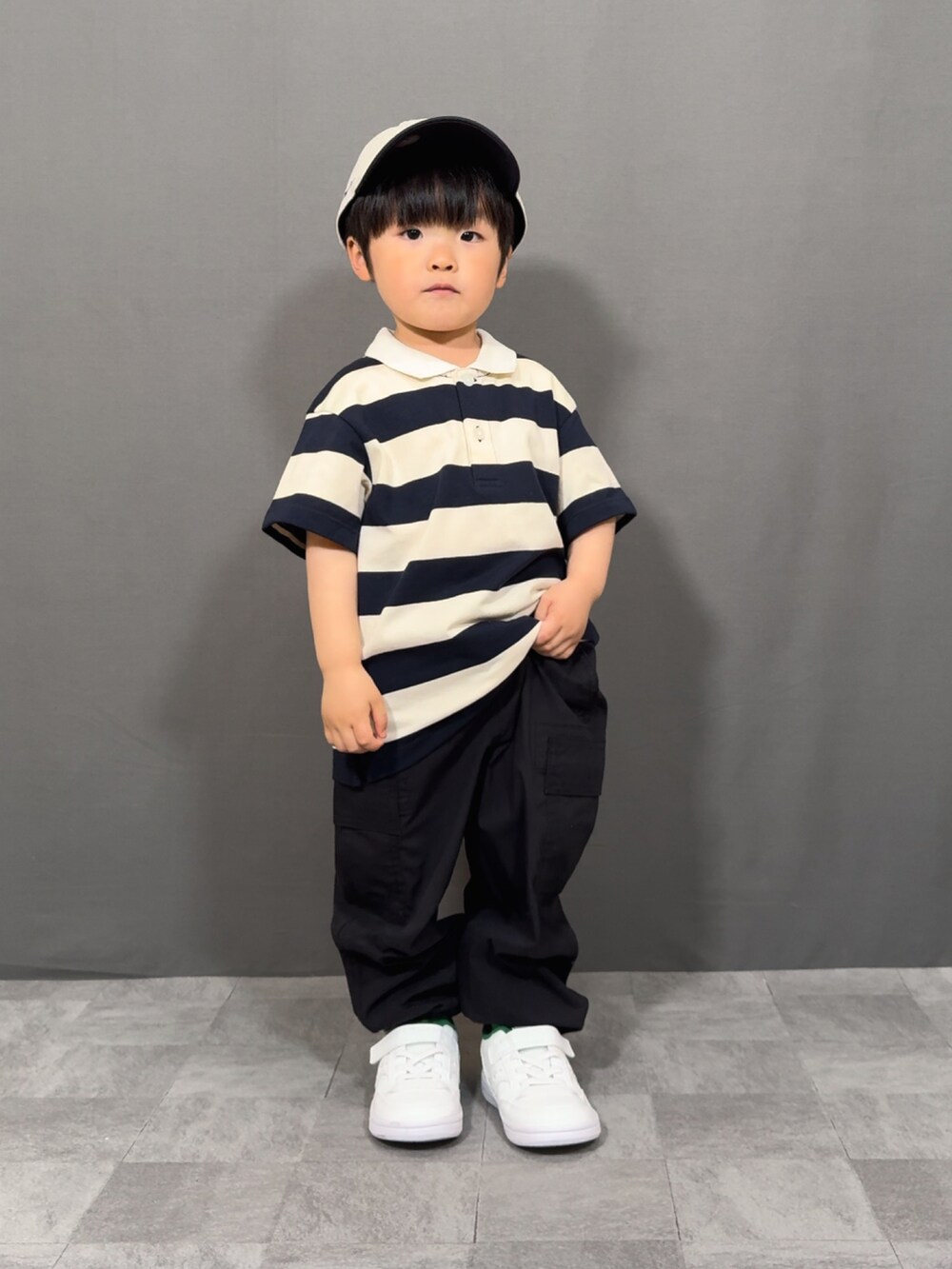 ベージュ系のトップス、ブラック系のパンツ、ホワイト系のショルダーバッグを着用したキッズの春コーディネートの3枚目の写真