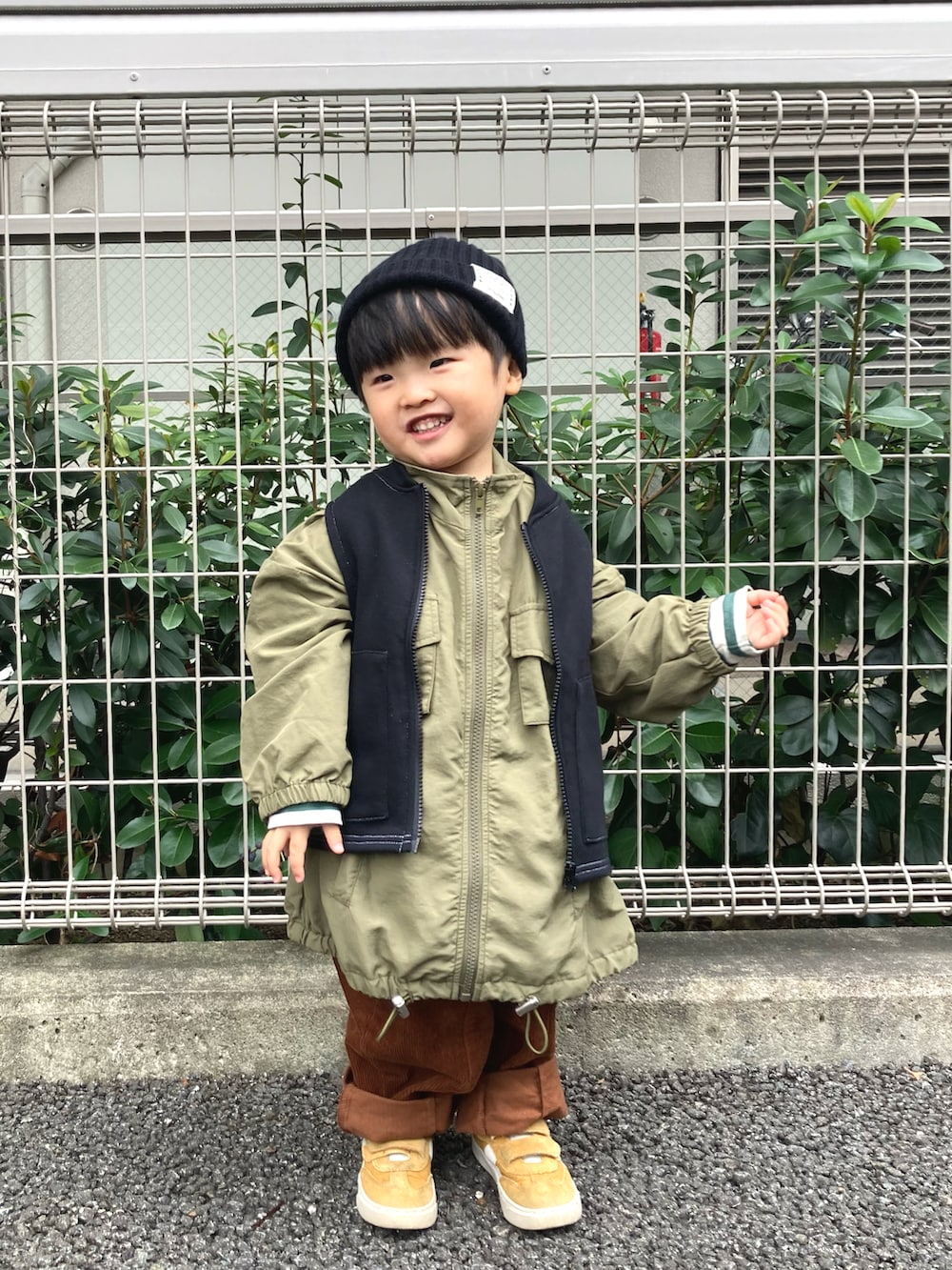 グリーン系のジャケット/アウター、ブラック系のベスト、グリーン系のTシャツ/カットソーを着用したキッズの秋コーディネートの3枚目の写真