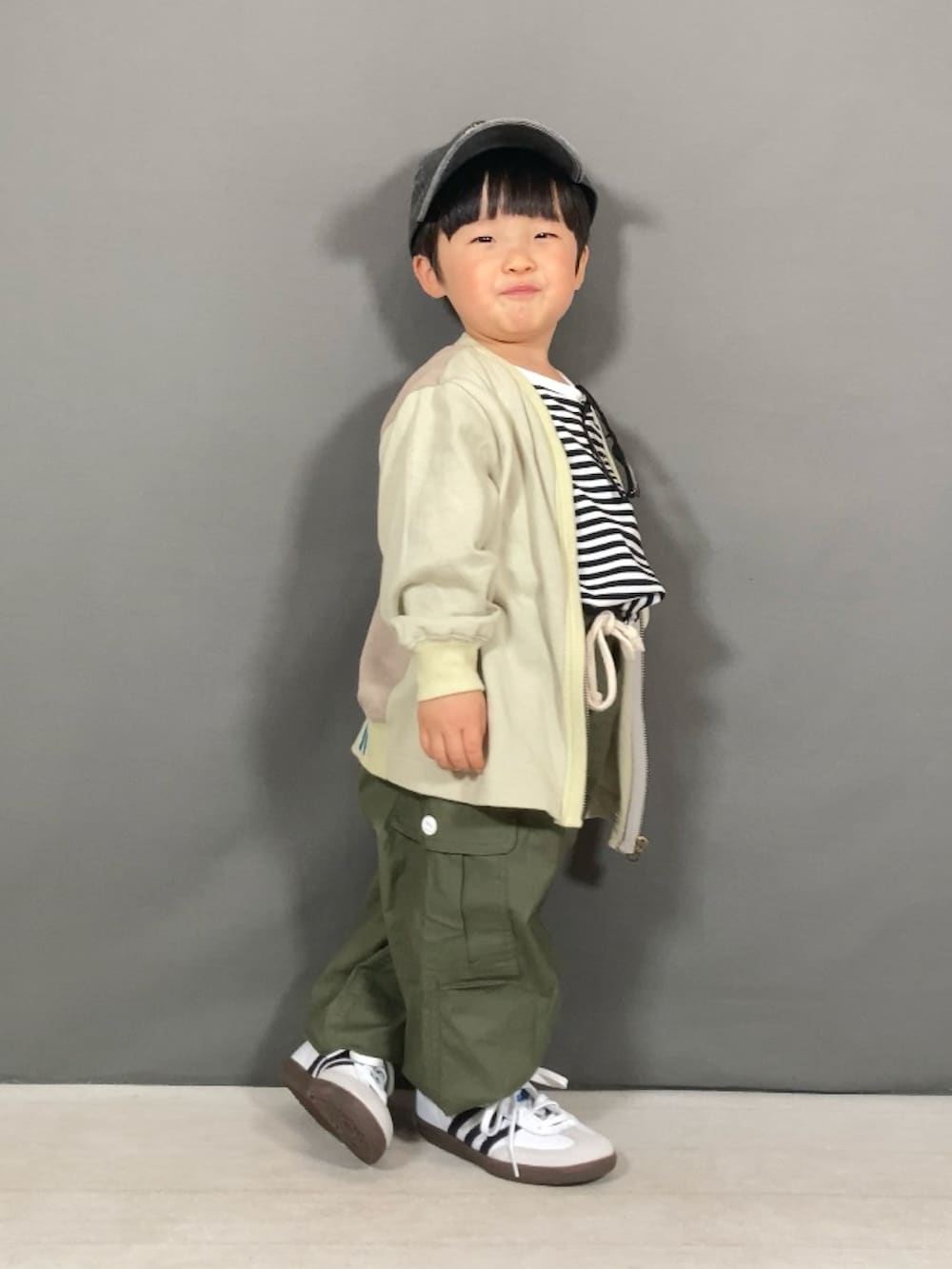 ベージュ系のカーディガン/ボレロ、ホワイト系のTシャツ/カットソー、グリーン系のカーゴパンツを着用したキッズの春コーディネートの3枚目の写真