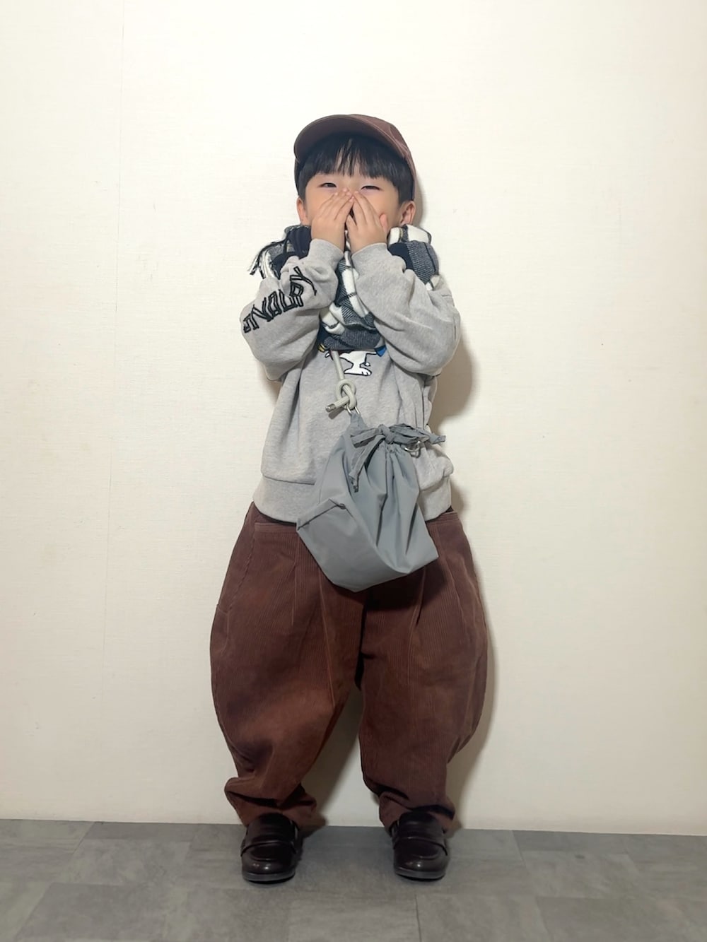 ブラウン系のその他パンツ、ブラウン系のローファー、グレー系のショルダーバッグを着用したキッズの冬コーディネートの3枚目の写真