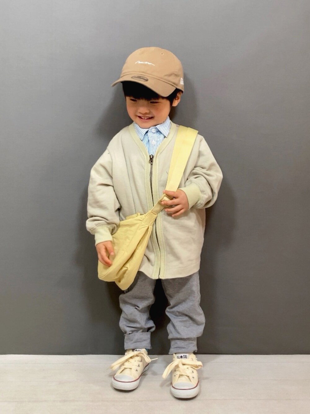 ベージュ系のカーディガン/ボレロ、ブルー系のシャツ/ブラウス、グレー系のスウェットパンツを着用したキッズの冬コーディネートの2枚目の写真