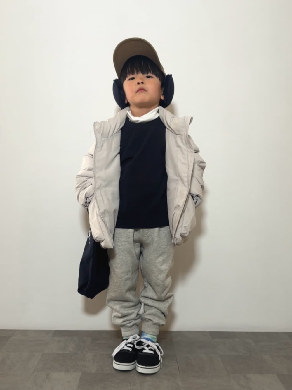 ブラック系のスニーカー、ホワイト系のTシャツ/カットソー、ブルー系のニット/セーターを着用したキッズの冬コーディネートの3枚目の写真