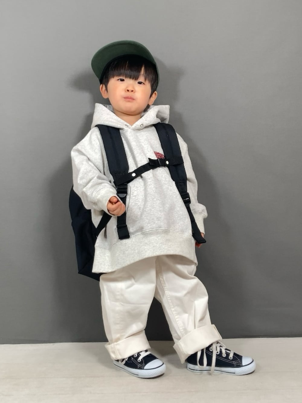 グレー系のスウェット、ホワイト系のパンツ、ブラック系のバックパック/リュックを着用したキッズの春コーディネートの2枚目の写真