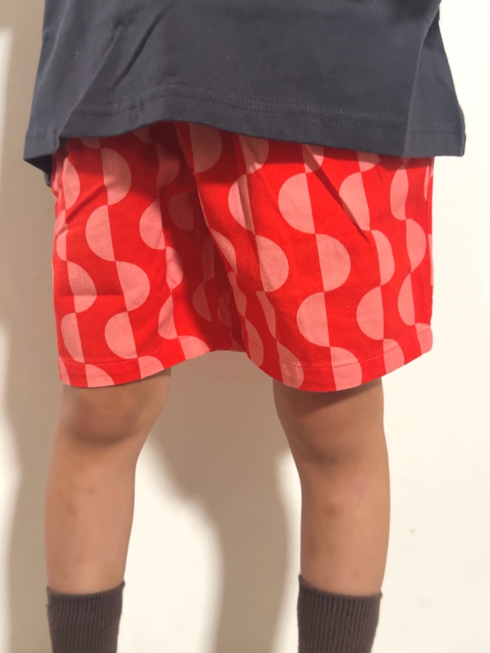 レッド系のその他パンツ、グレー系のTシャツ/カットソー、ベージュ系のモカシン/デッキシューズを着用したキッズの夏コーディネートの5枚目の写真