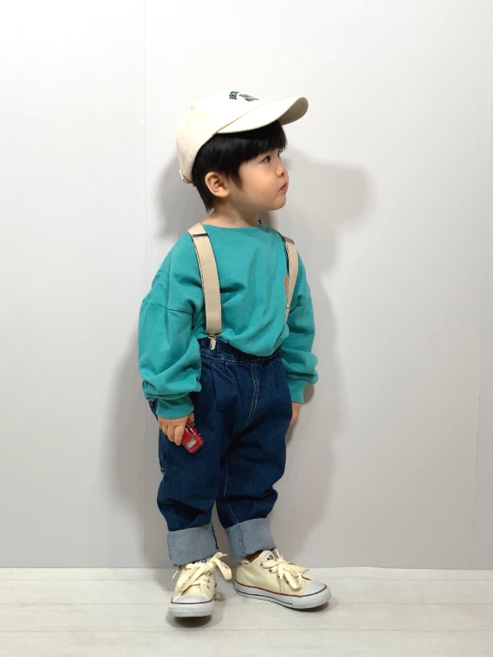 グリーン系のTシャツ/カットソー、ブルー系のデニムパンツ、ホワイト系のスニーカーを着用したキッズの冬コーディネートの2枚目の写真