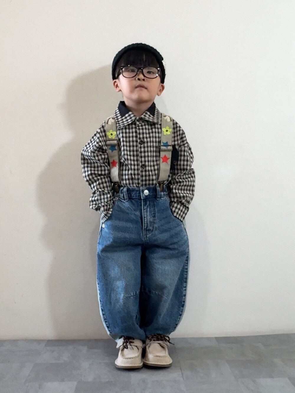 ブラック系のシャツ/ブラウス、ベージュ系のモカシン/デッキシューズ、ブルー系のデニムパンツを着用したキッズの秋コーディネートの2枚目の写真