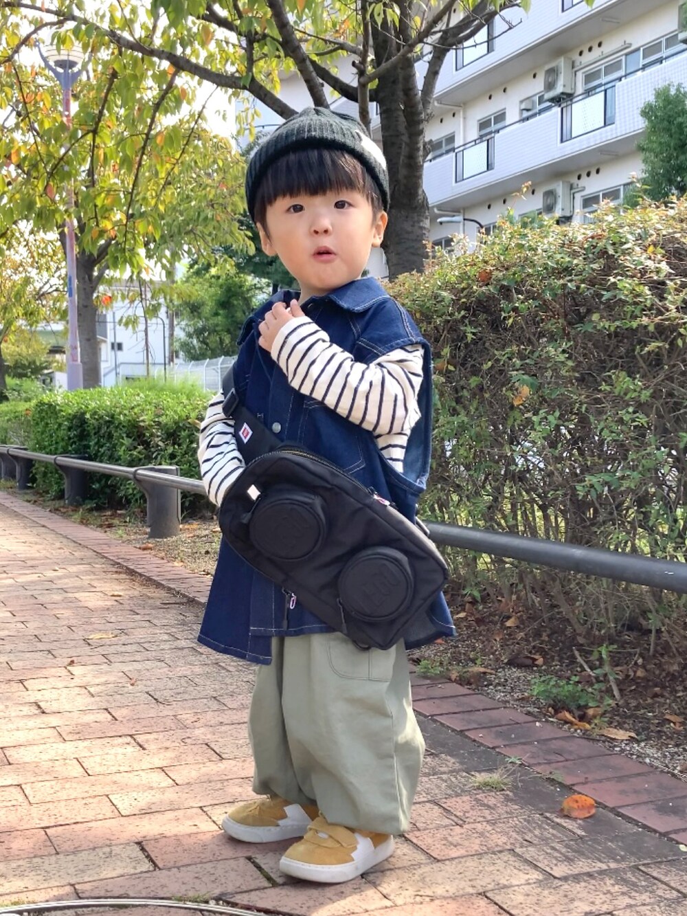 ブルー系のベスト、ホワイト系のTシャツ/カットソー、グリーン系のカーゴパンツを着用したキッズの秋コーディネートの3枚目の写真