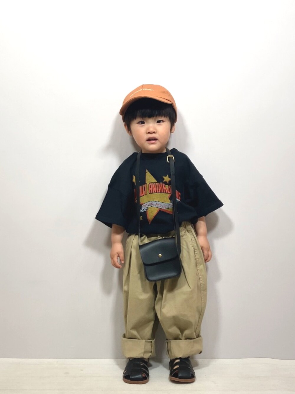 ブラック系のTシャツ/カットソー、ベージュ系のその他パンツ、ブラック系のショルダーバッグを着用したキッズの春コーディネートの3枚目の写真