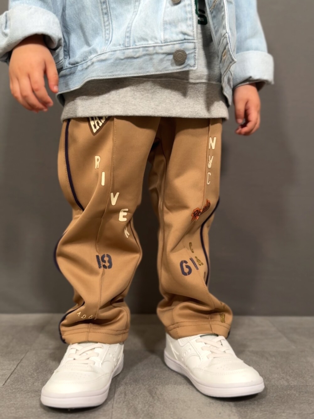ブルー系のデニムジャケット、グレー系のスウェット、ベージュ系のその他パンツを着用したキッズの冬コーディネートの4枚目の写真