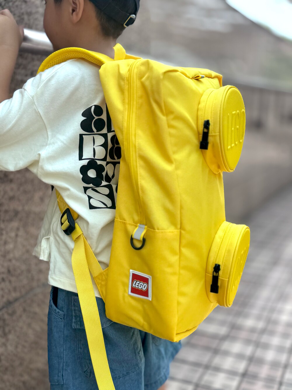 ブラック系のTシャツ/カットソー、ブルー系のその他パンツ、イエロー系のバックパック/リュックを着用したキッズの秋コーディネートの4枚目の写真