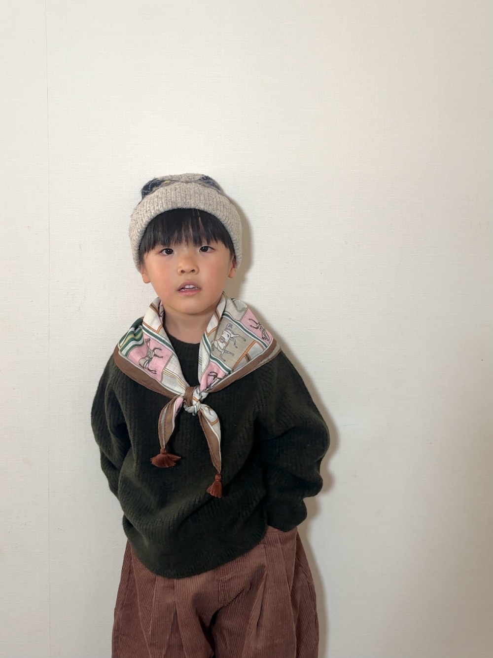 ブラウン系のローファー、ブラウン系のその他パンツ、グリーン系のニット/セーターを着用したキッズの秋コーディネートの4枚目の写真