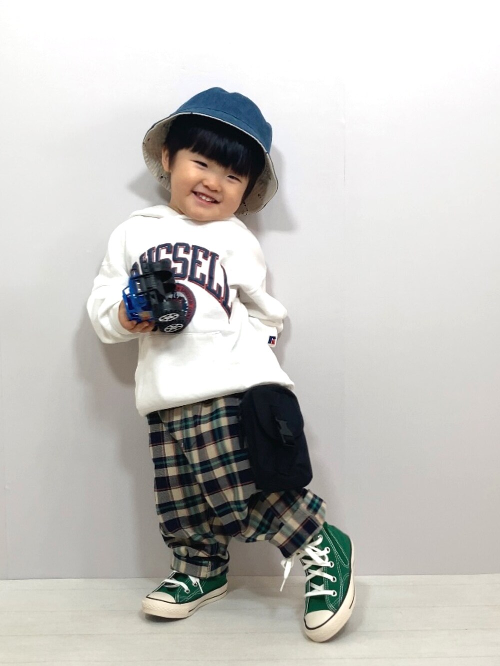 ホワイト系のスウェット、ブルー系のその他パンツ、ブラック系のバッグを着用したキッズの冬コーディネートの2枚目の写真