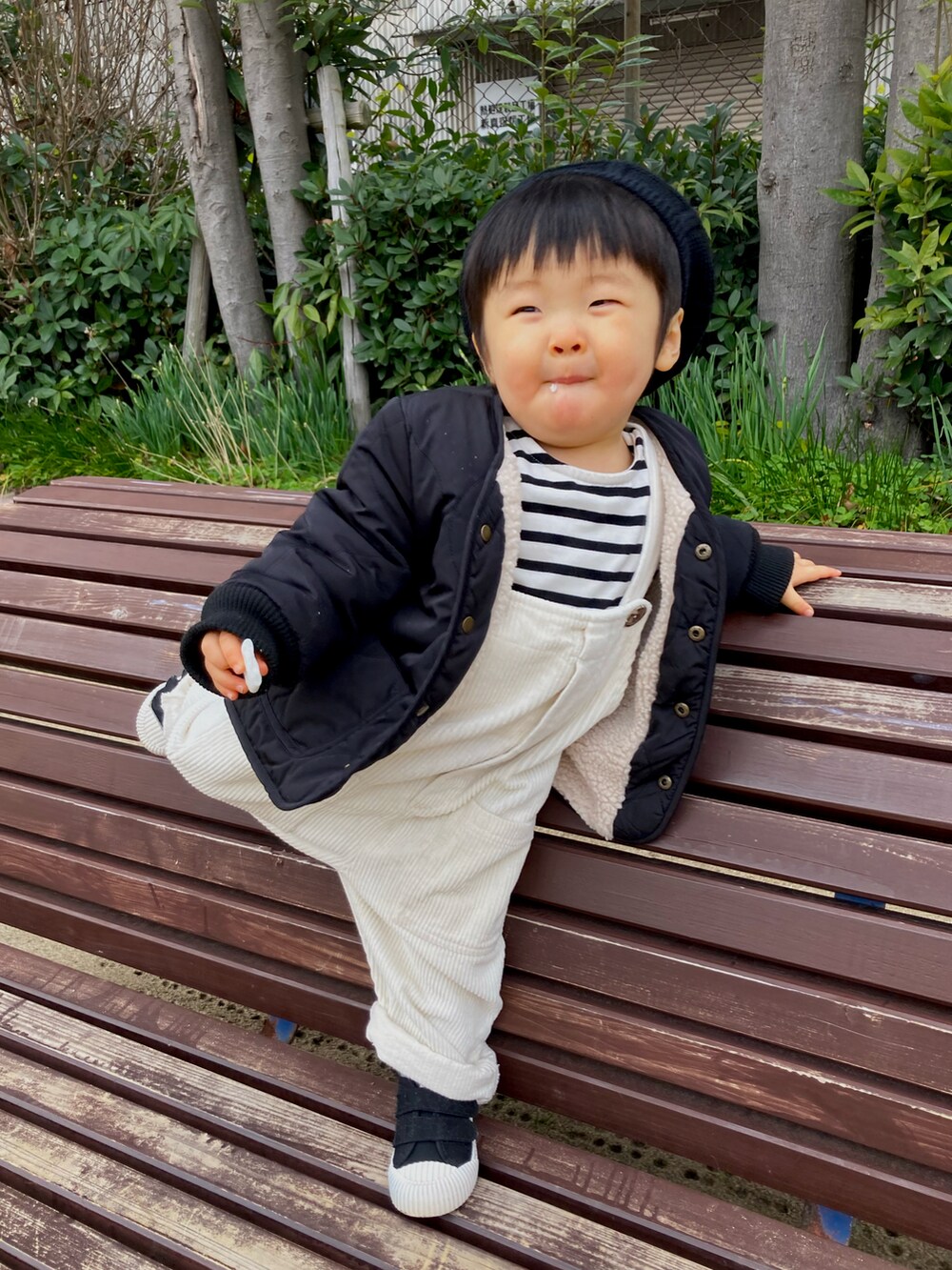 ブラック系のジャケット/アウター、ホワイト系のTシャツ/カットソー、ベージュ系のサロペット/オーバーオールを着用したキッズの冬コーディネートの2枚目の写真