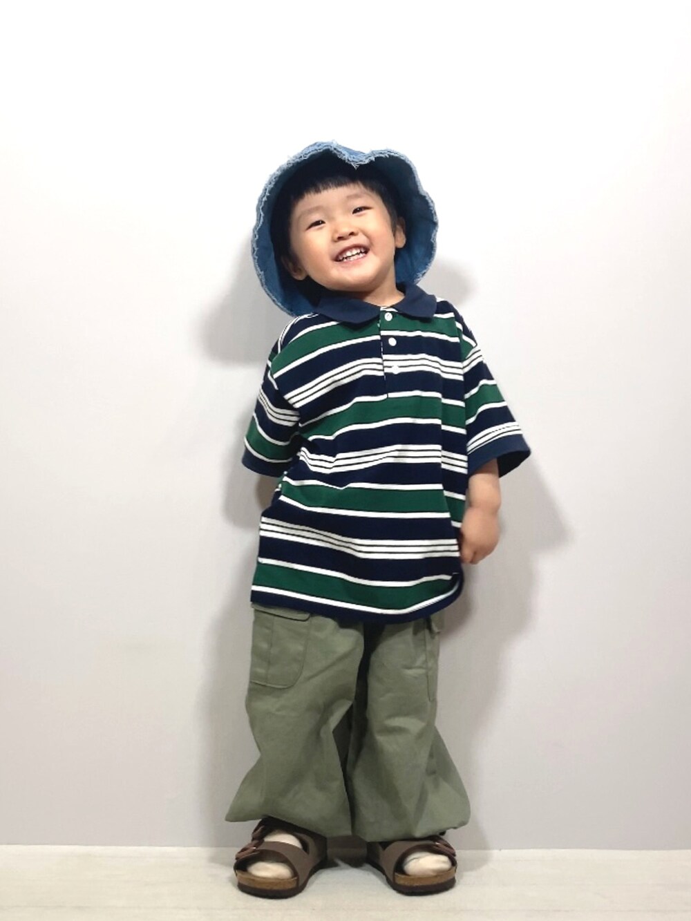 ブルー系のポロシャツ、グリーン系のカーゴパンツ、ブラウン系のサンダルを着用したキッズの夏コーディネートの4枚目の写真