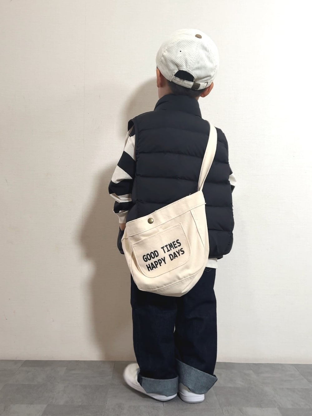 ホワイト系のスニーカー、ブラック系のベスト、ホワイト系のポロシャツを着用したキッズの秋コーディネートの4枚目の写真