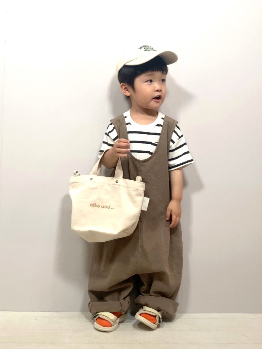 ホワイト系のTシャツ/カットソー、ブラウン系のオールインワン・サロペット、ホワイト系のショルダーバッグを着用したキッズの夏コーディネートの4枚目の写真