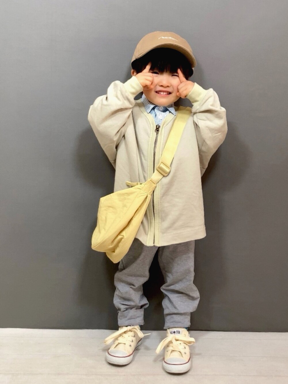 ベージュ系のカーディガン/ボレロ、ブルー系のシャツ/ブラウス、グレー系のスウェットパンツを着用したキッズの冬コーディネートの3枚目の写真