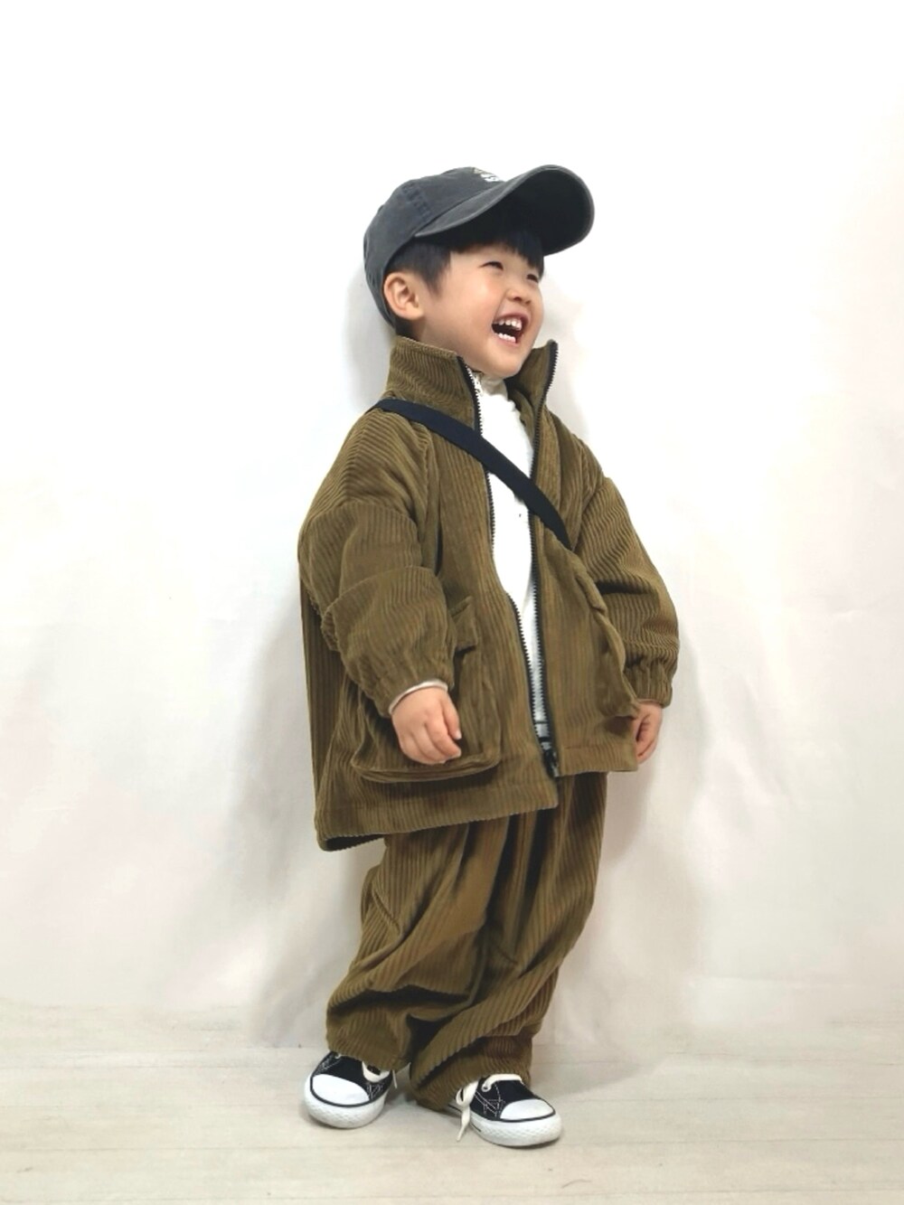 グリーン系のブルゾン、グリーン系のその他パンツ、ブラック系のメッセンジャーバッグを着用したキッズの冬コーディネートの5枚目の写真