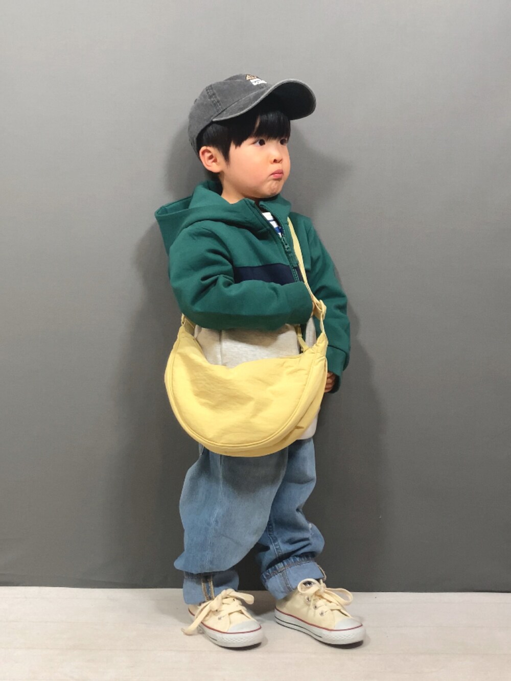 グリーン系のパーカー、ブルー系のTシャツ/カットソー、ブルー系のデニムパンツを着用したキッズの冬コーディネートの4枚目の写真