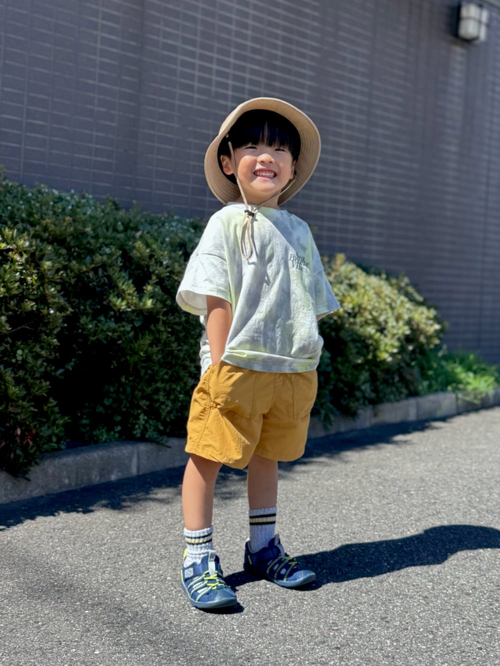 ブルー系のサンダル、グレー系のTシャツ/カットソー、イエロー系のパンツを着用したキッズの夏コーディネートの3枚目の写真