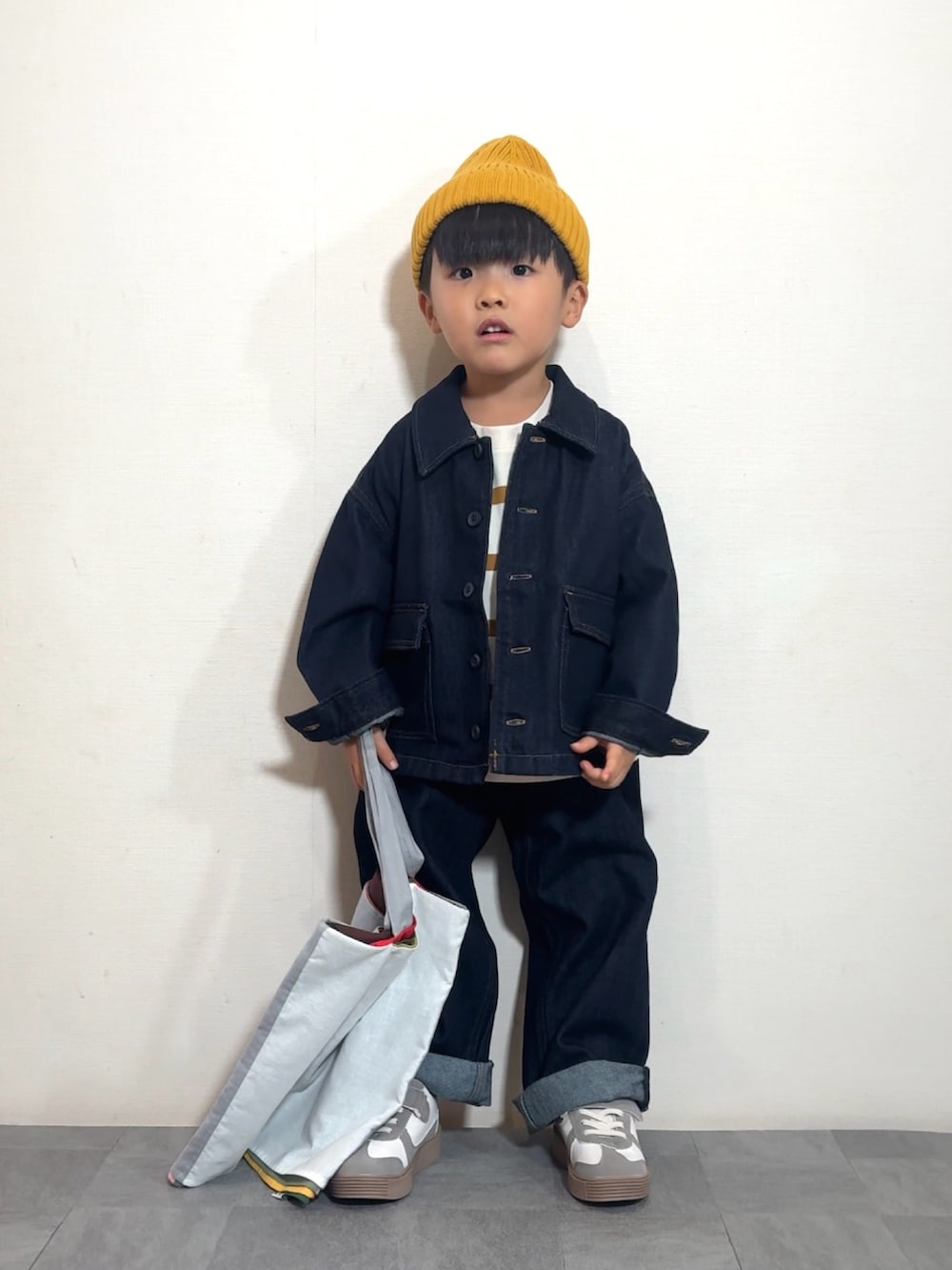 イエロー系のTシャツ/カットソー、ブルー系のデニムジャケット、ブルー系のデニムパンツを着用したキッズの秋コーディネートの2枚目の写真