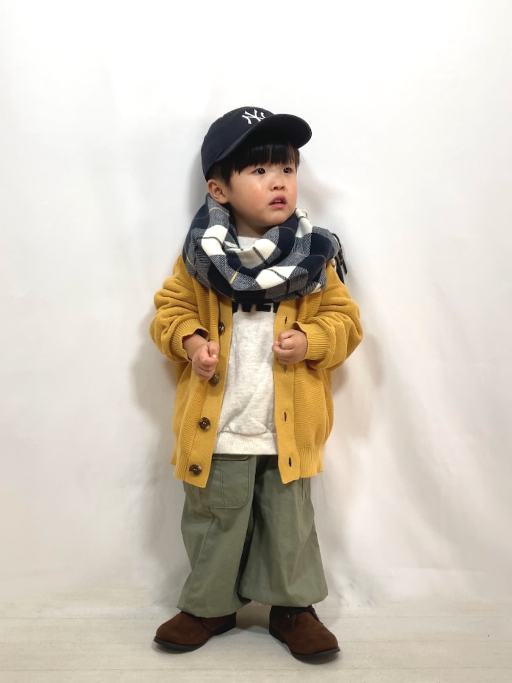 イエロー系のカーディガン/ボレロ、グレー系のスウェット、グリーン系のカーゴパンツを着用したキッズの秋コーディネートの3枚目の写真