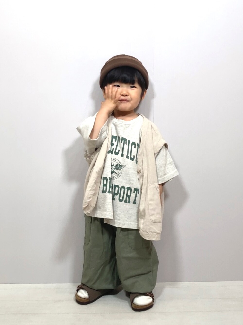 グレー系のTシャツ/カットソー、ホワイト系のベスト、グリーン系のカーゴパンツを着用したキッズの春コーディネートの2枚目の写真