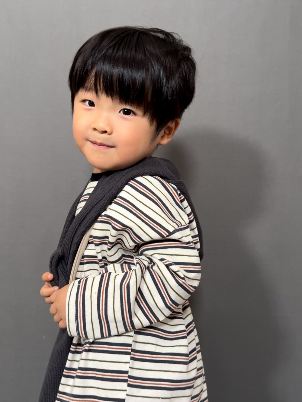 ホワイト系のトップス、ブルー系のデニムパンツ、ベージュ系のショルダーバッグを着用したキッズの秋コーディネートの4枚目の写真