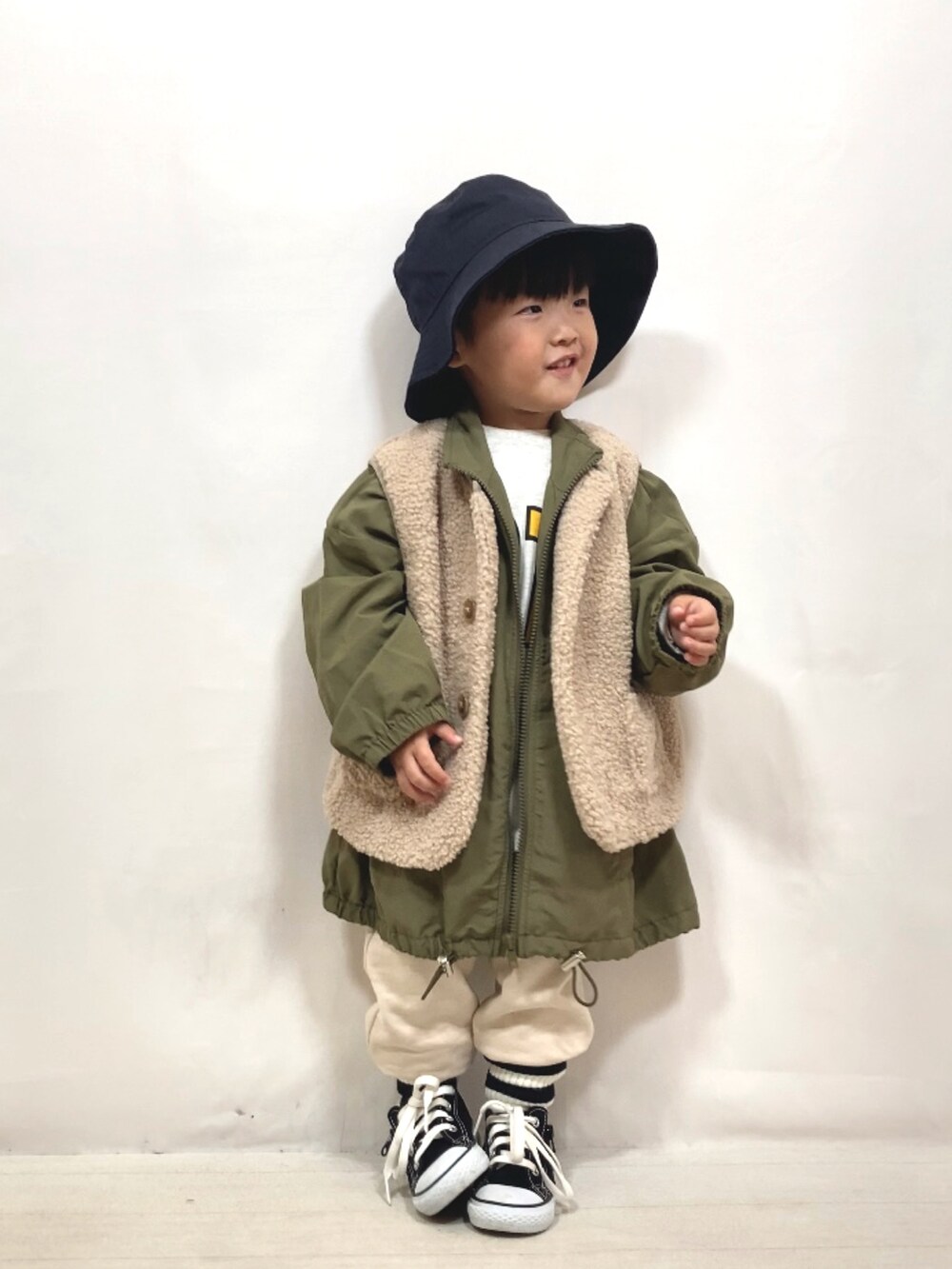 ベージュ系のベスト、グリーン系のジャケット/アウター、グレー系のTシャツ/カットソーを着用したキッズの秋コーディネートの3枚目の写真