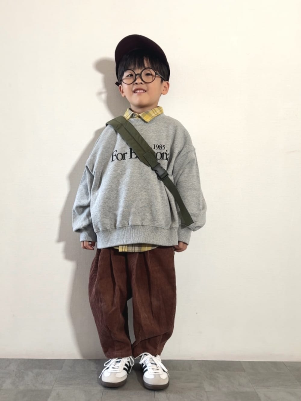 グレー系のスウェット、ブラウン系のその他パンツ、イエロー系のシャツ/ブラウスを着用したキッズの秋コーディネートの2枚目の写真