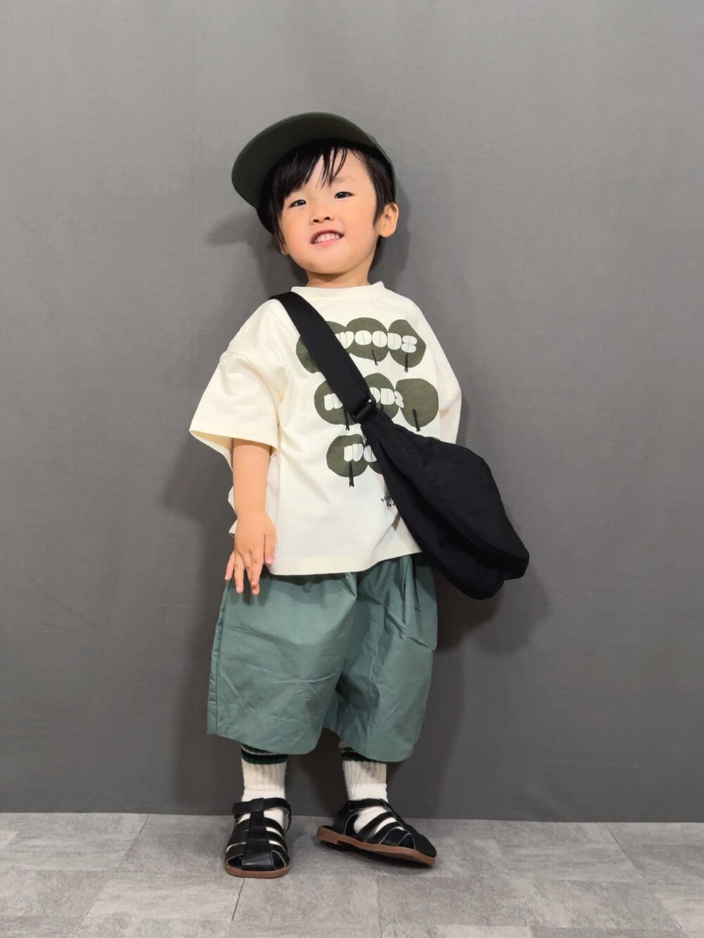 ブラック系のTシャツ/カットソー、グリーン系のその他パンツ、ブラック系のショルダーバッグを着用したキッズの春コーディネートの4枚目の写真