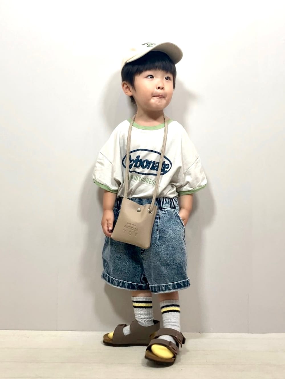 グレー系のTシャツ/カットソー、ブルー系のデニムパンツ、ベージュ系のショルダーバッグを着用したキッズの夏コーディネートの3枚目の写真