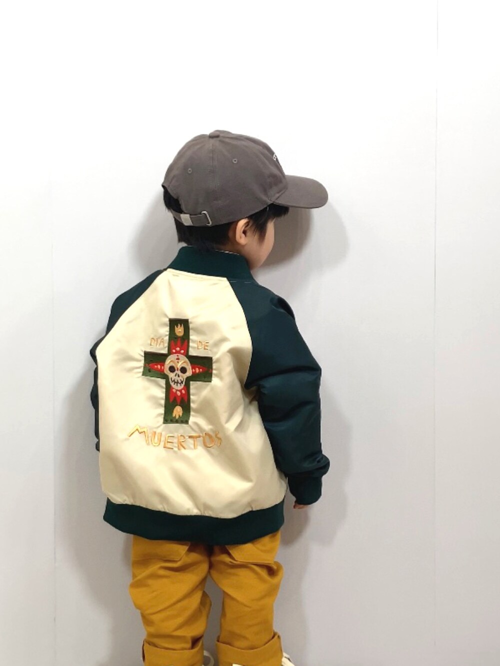 グリーン系のブルゾン、ホワイト系のシャツ/ブラウス、イエロー系のその他パンツを着用したキッズの春コーディネートの3枚目の写真