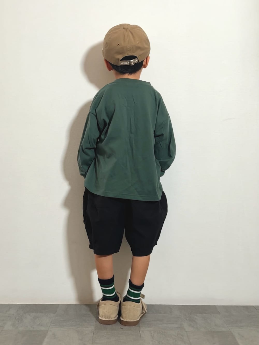 ブラック系のその他パンツ、ベージュ系のモカシン/デッキシューズ、グリーン系のTシャツ/カットソーを着用したキッズの秋コーディネートの3枚目の写真