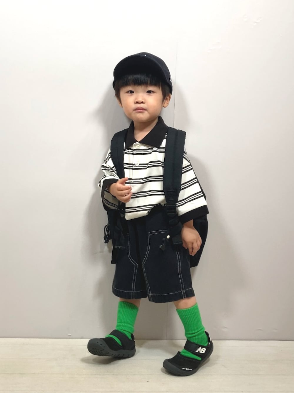 ベージュ系のポロシャツ、ブラック系のその他パンツ、ブラック系のバックパック/リュックを着用したキッズの夏コーディネートの2枚目の写真