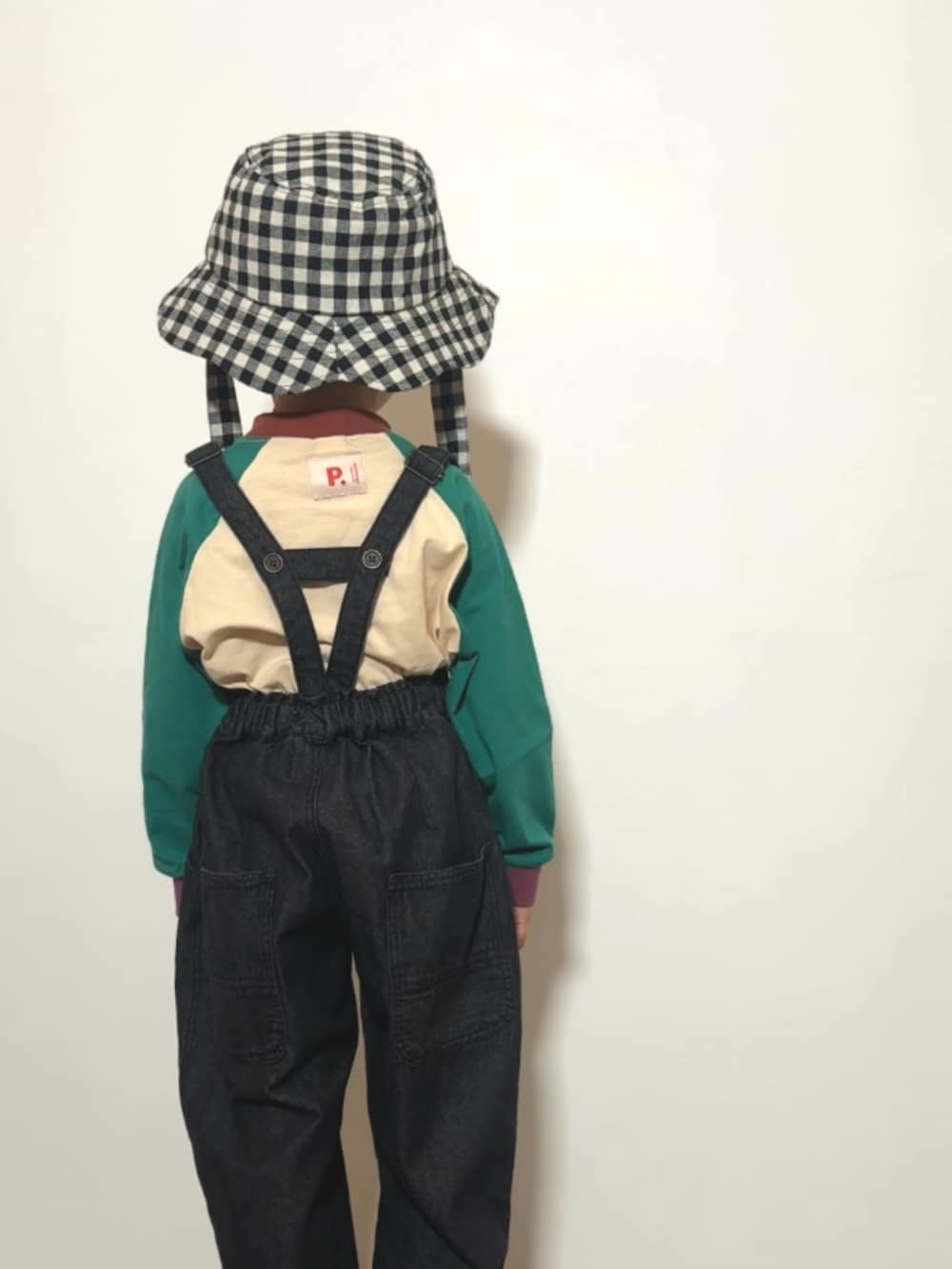 ブラック系のサロペット/オーバーオール、ブラウン系のローファー、グリーン系のTシャツ/カットソーを着用したキッズの春コーディネートの3枚目の写真