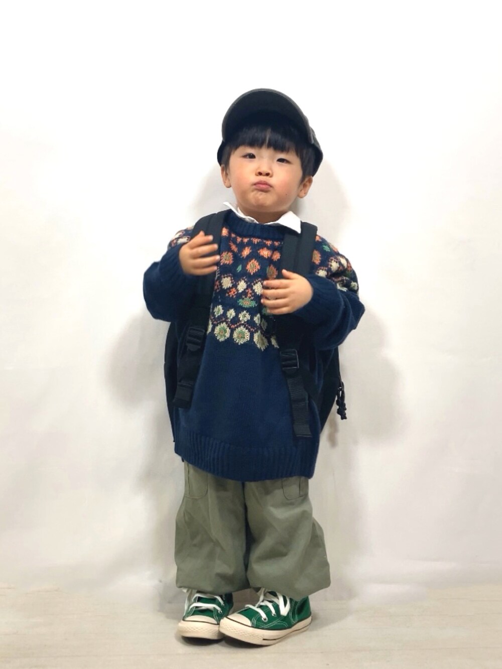 ブルー系のニット/セーター、ホワイト系のシャツ/ブラウス、グリーン系のカーゴパンツを着用したキッズの冬コーディネートの2枚目の写真