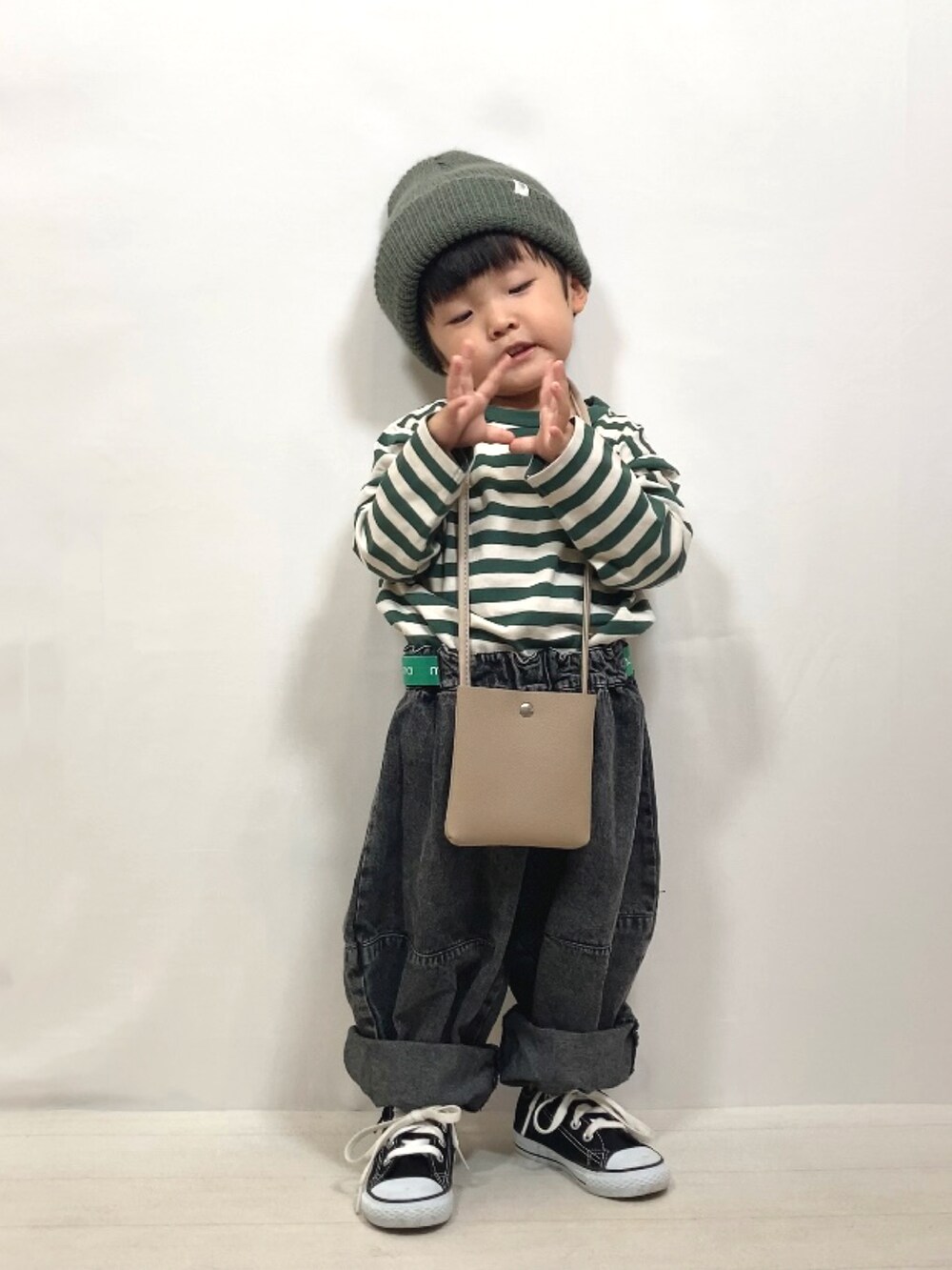 グリーン系のTシャツ/カットソー、ブラック系のデニムパンツ、ベージュ系のショルダーバッグを着用したキッズの夏コーディネートの4枚目の写真