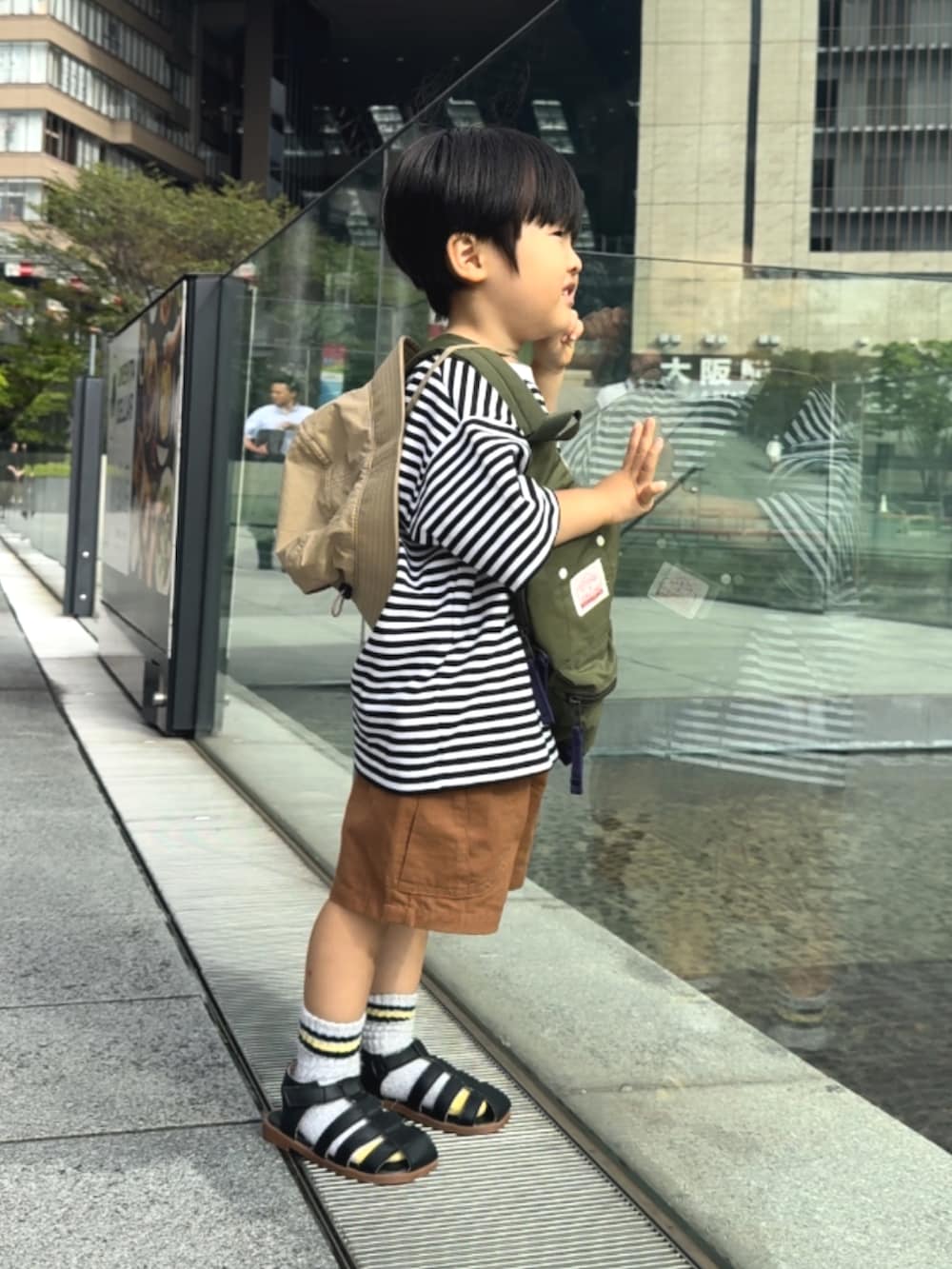 ホワイト系のTシャツ/カットソー、ブラウン系のその他パンツ、グリーン系のボディバッグ/ウエストポーチを着用したキッズの夏コーディネートの2枚目の写真