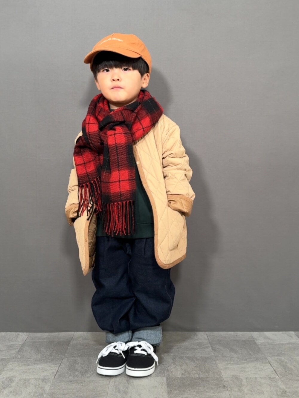 ベージュ系のジャケット/アウター、グリーン系のスウェット、ブルー系のデニムパンツを着用したキッズの冬コーディネートの2枚目の写真