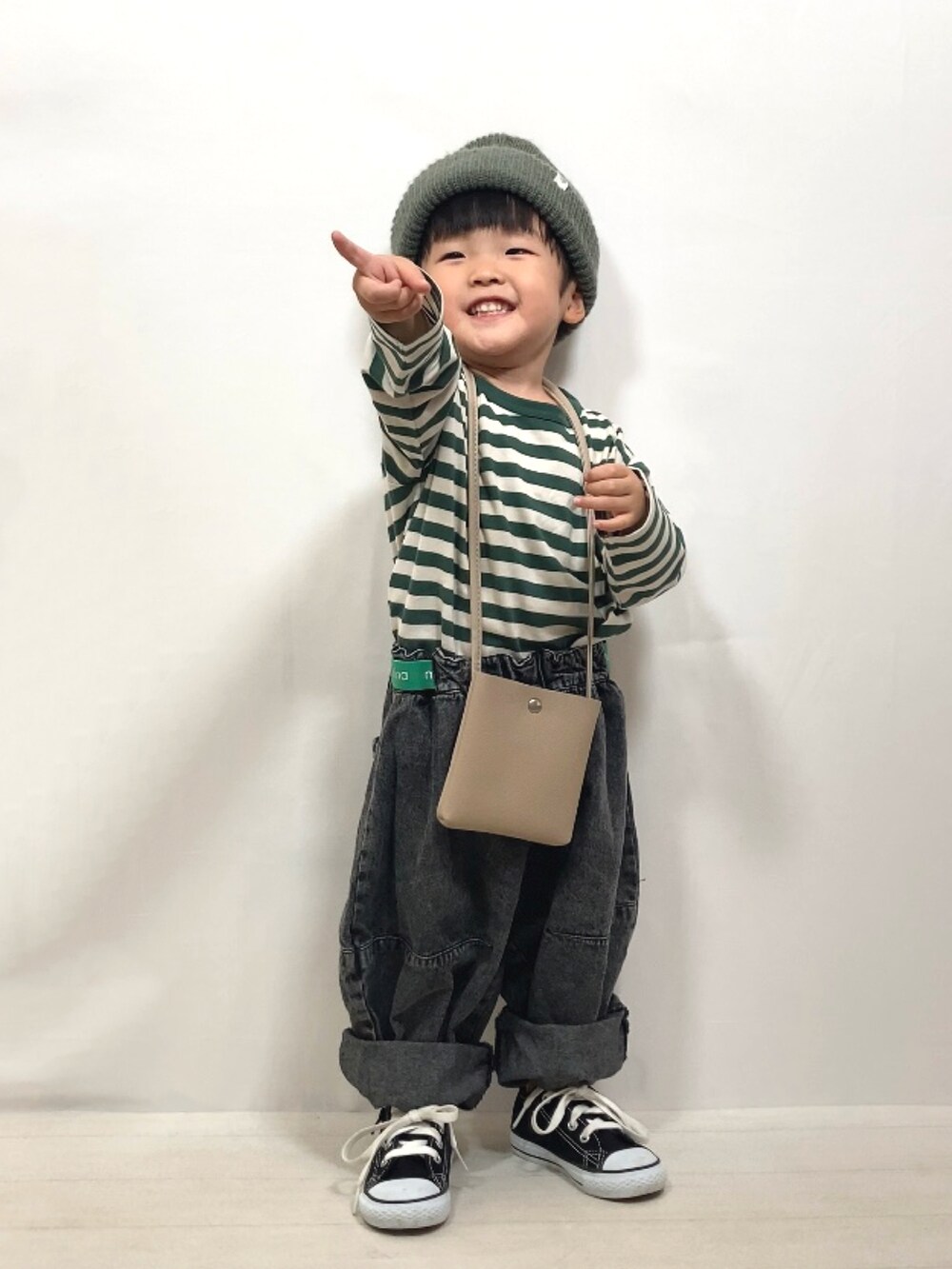 グリーン系のTシャツ/カットソー、ブラック系のデニムパンツ、ベージュ系のショルダーバッグを着用したキッズの夏コーディネートの3枚目の写真