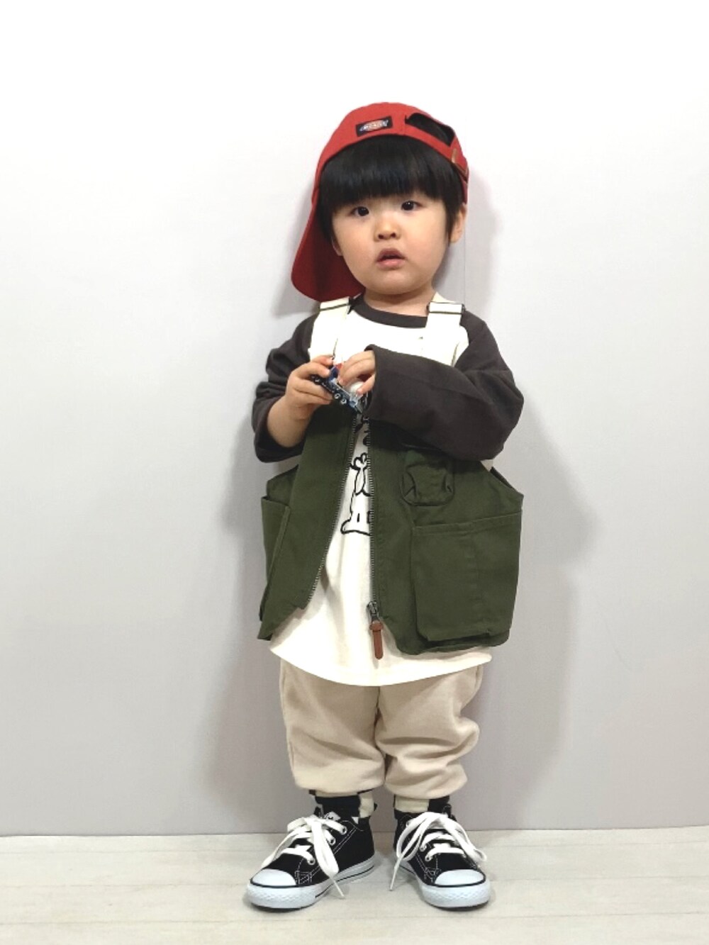 グリーン系のベスト、グレー系のTシャツ/カットソー、ホワイト系のスウェットパンツを着用したキッズの春コーディネートの2枚目の写真