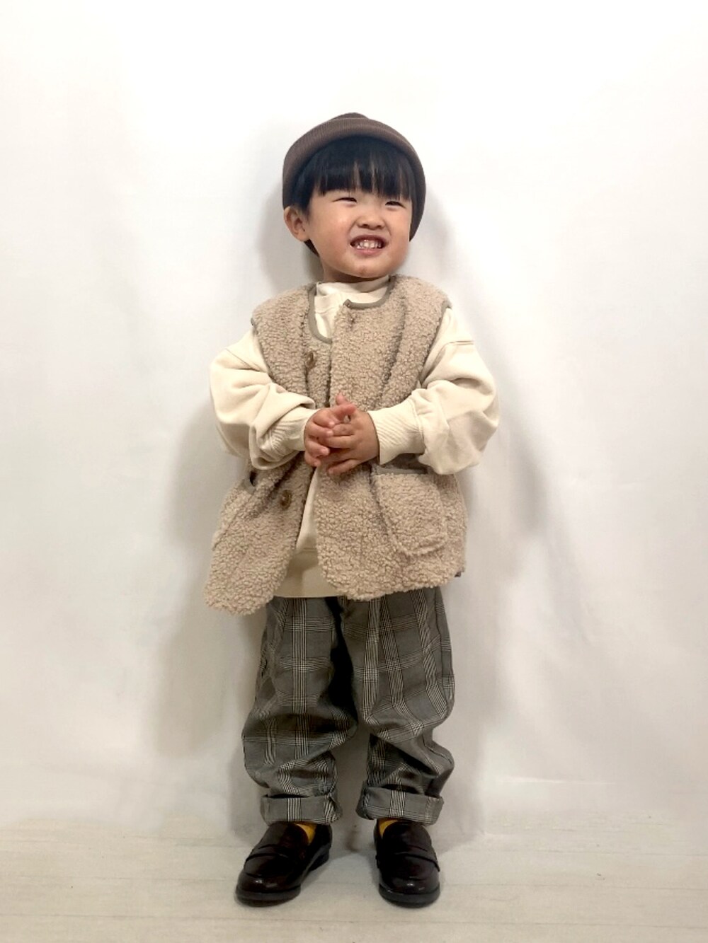 ベージュ系のベスト、ベージュ系のスウェット、ホワイト系のTシャツ/カットソーを着用したキッズの秋コーディネートの5枚目の写真