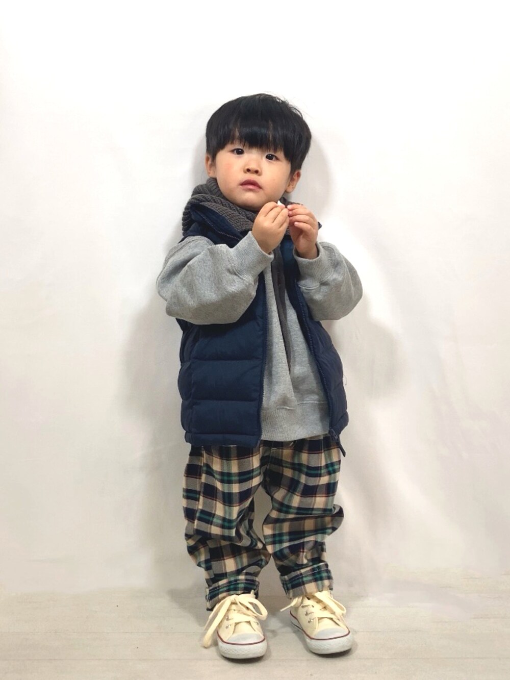 グレー系のスウェット、ブルー系のダウンベスト、ブルー系のその他パンツを着用したキッズの秋コーディネートの4枚目の写真