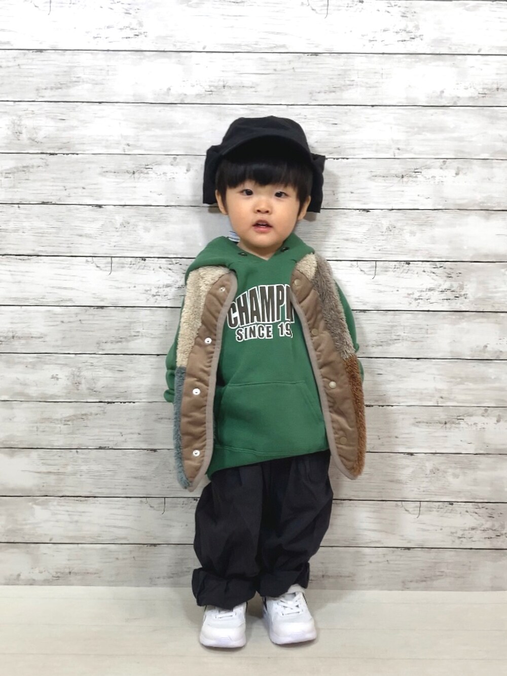 その他のベスト、グリーン系のパーカー、グレー系のその他パンツを着用したキッズの秋コーディネートの2枚目の写真