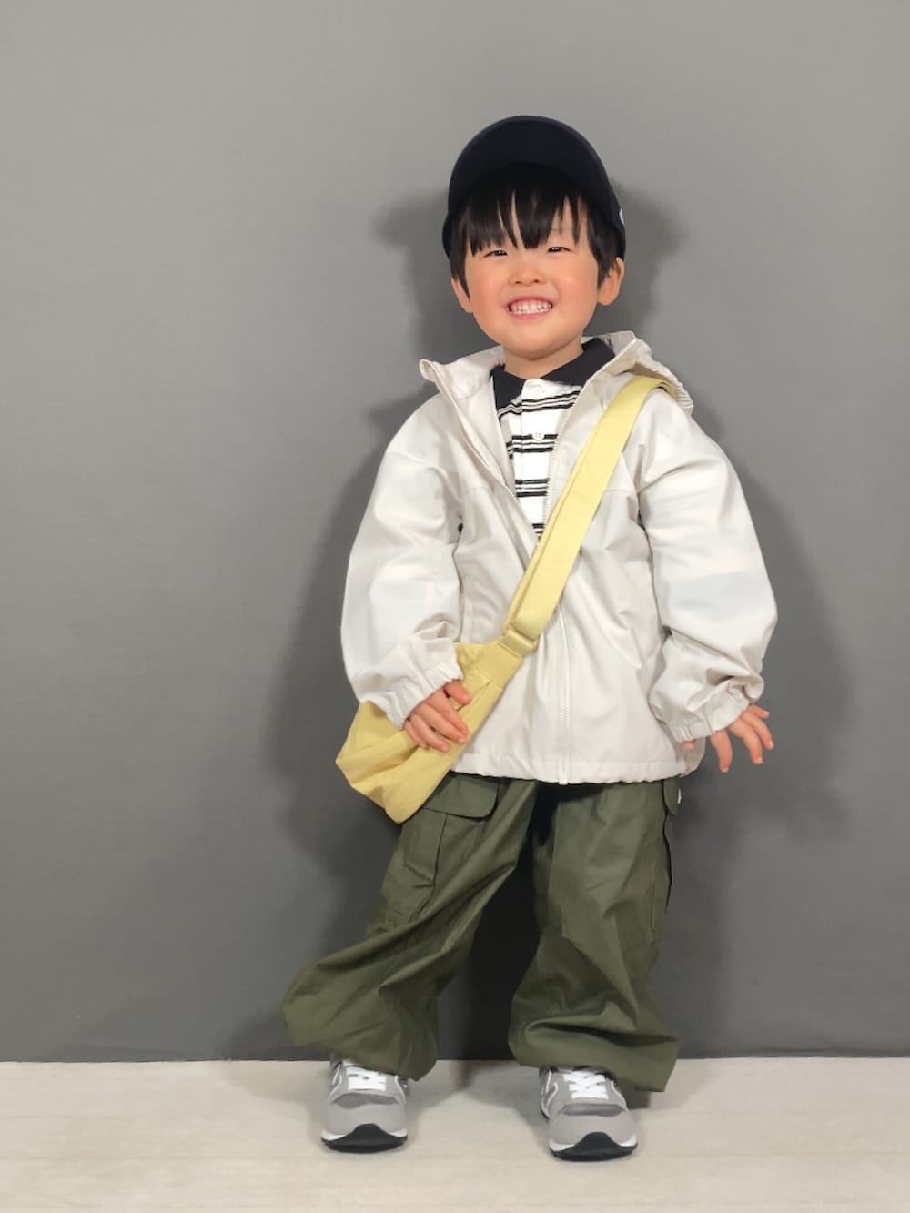 ホワイト系のジャケット/アウター、ベージュ系のポロシャツ、グリーン系のカーゴパンツを着用したキッズの春コーディネートの2枚目の写真