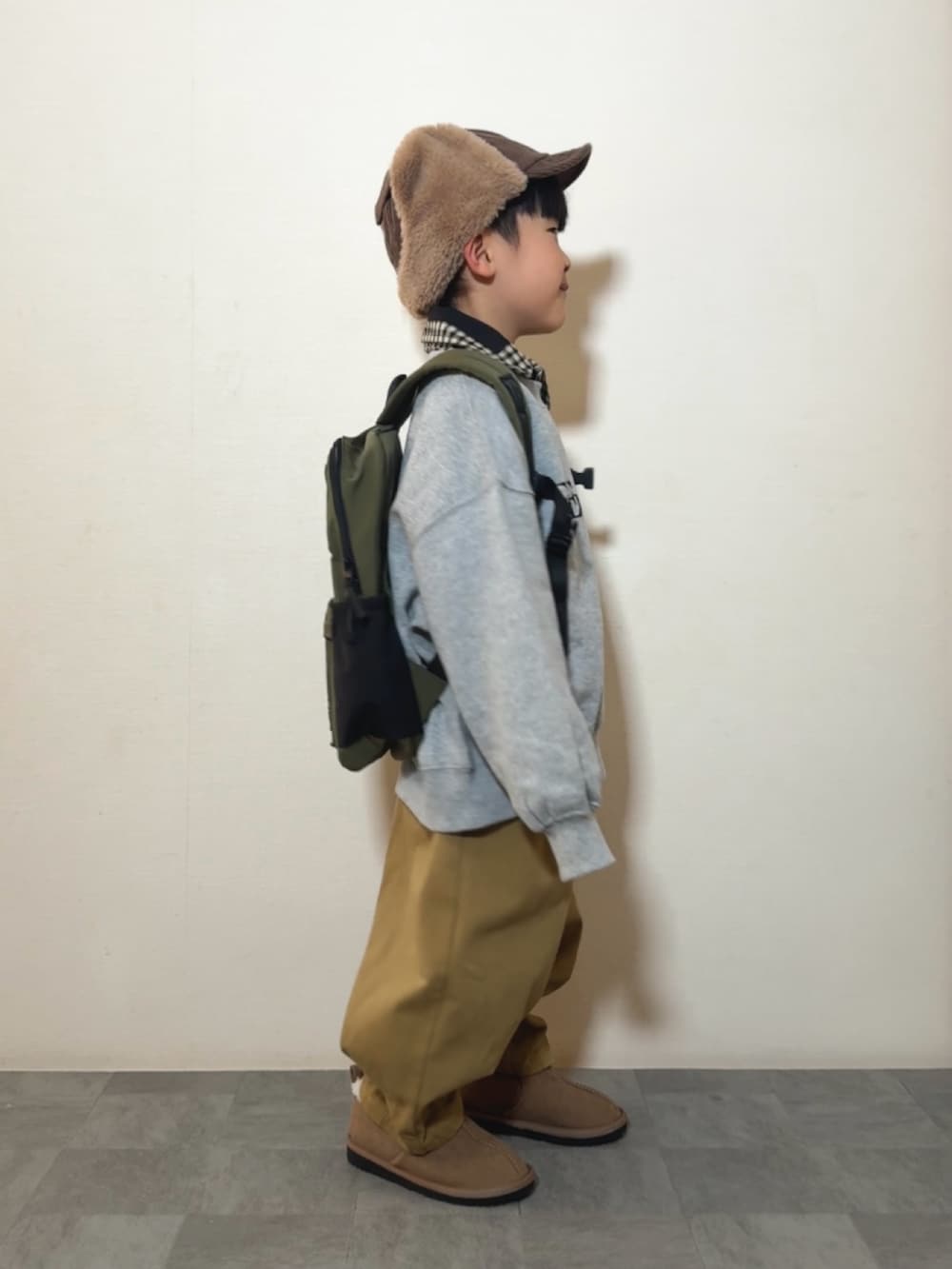 グレー系のスウェット、ブラウン系のその他パンツ、イエロー系のブーツを着用したキッズの冬コーディネートの2枚目の写真