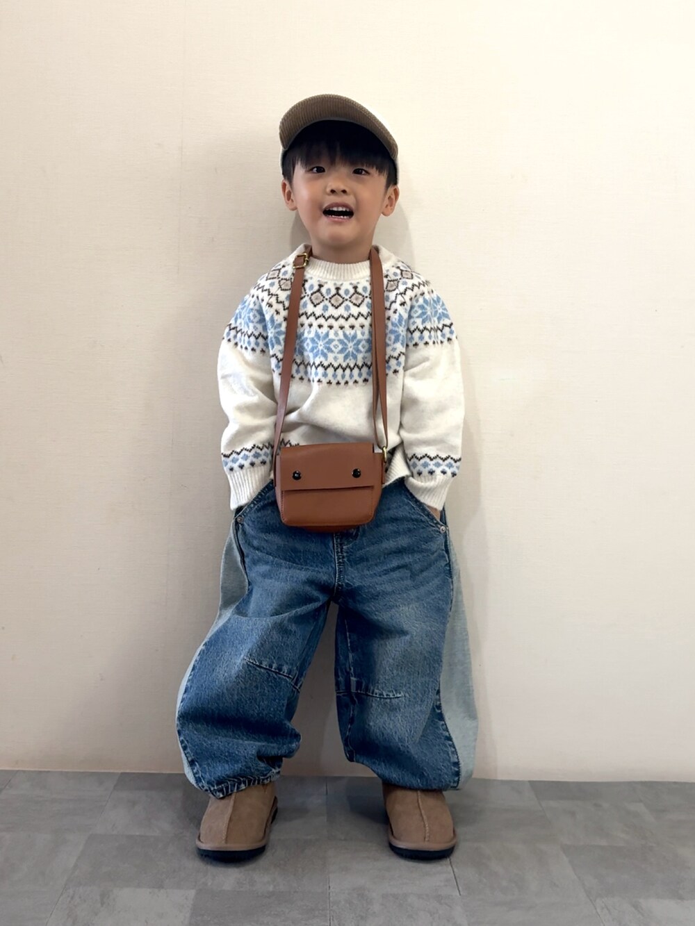 ブルー系のデニムパンツ、イエロー系のブーツ、ホワイト系のニット/セーターを着用したキッズの秋コーディネートの2枚目の写真