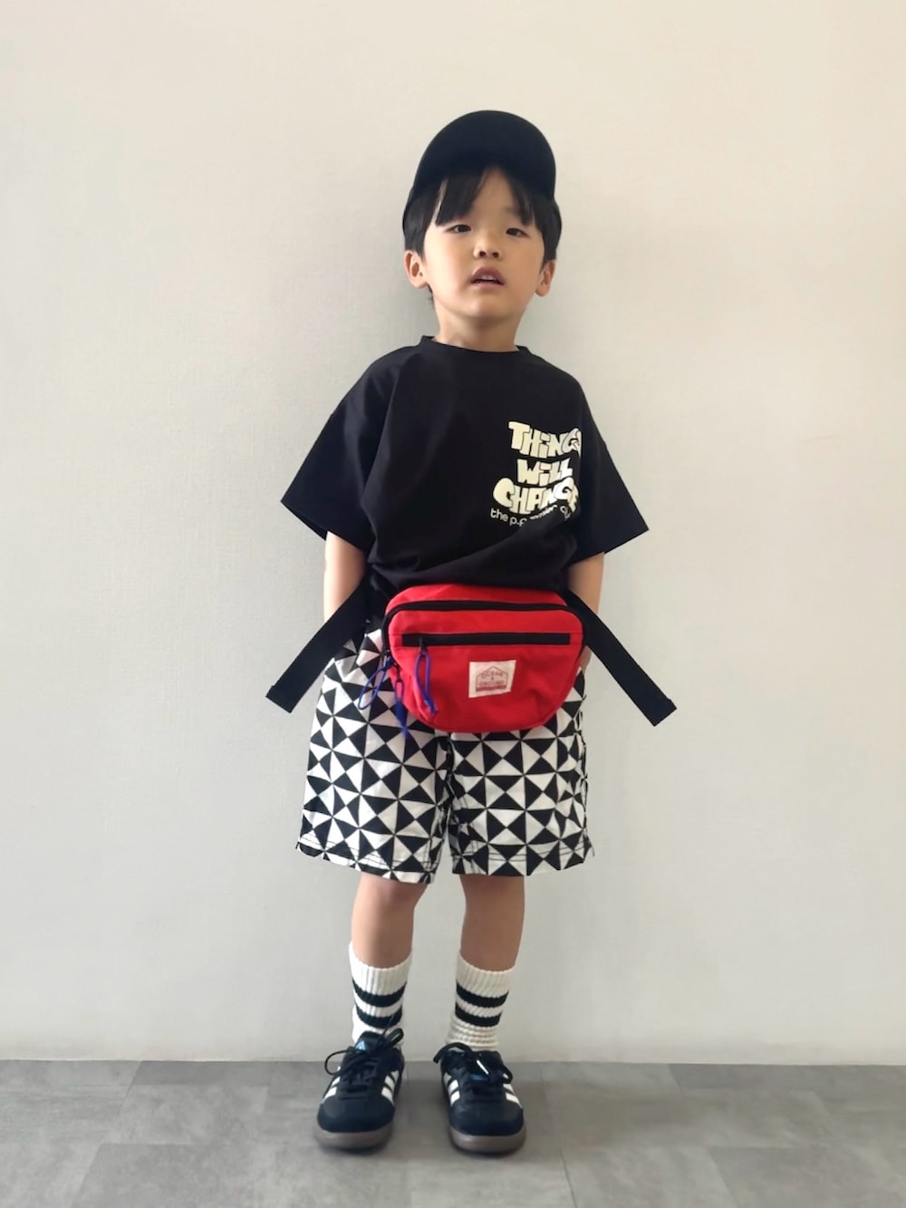 ブラック系のスニーカー、ブラック系のTシャツ/カットソー、レッド系のボディバッグ/ウエストポーチを着用したキッズの春コーディネートの4枚目の写真
